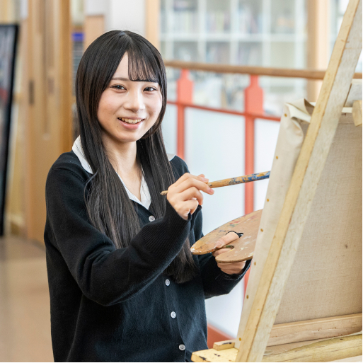 学生がキャンバスに絵を描く様子の写真
