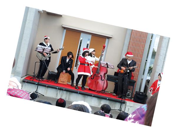 クリスマスの衣装でステージ演奏をする様子の写真