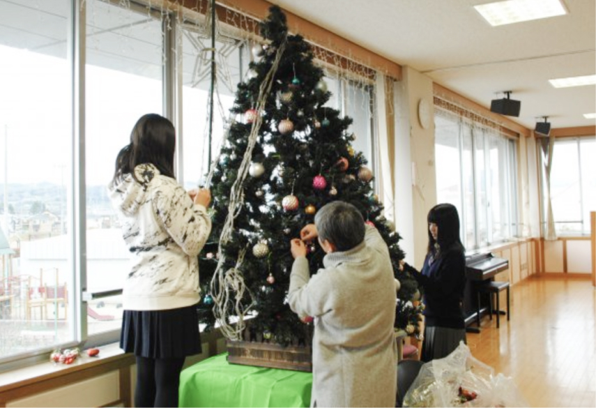 クリスマスツリーを飾り付けする様子の写真